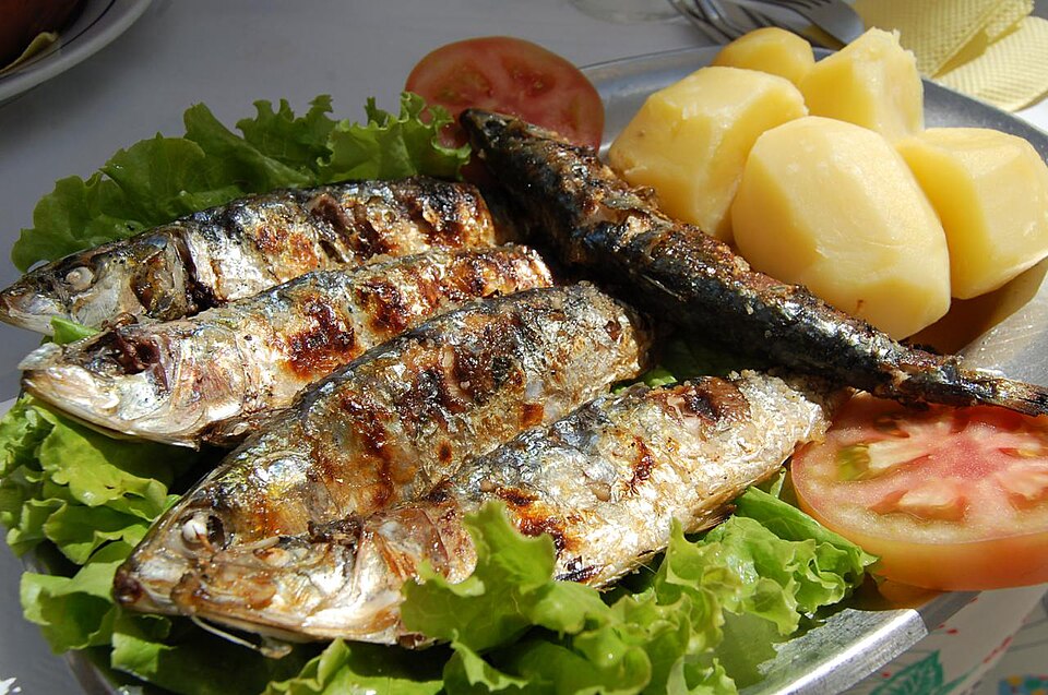 Plate of Grilled sardines with boiled potatoes, one of the most famous and traditional dishes in Portugal, served in a simple and authentic style.