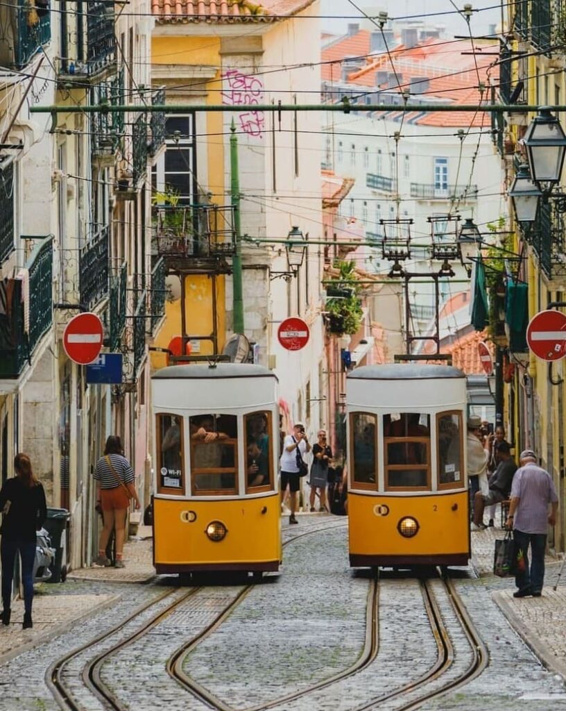 Morning atmosphere in Bairro Alto, Lisbon, with narrow streets, traditional buildings, and a lively mix of bars, music, and people enjoying the day.