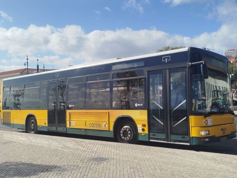 A Carris bus at Cais do Sodré in Lisbon, preparing to depart as people move through one of the city’s main transport connections.