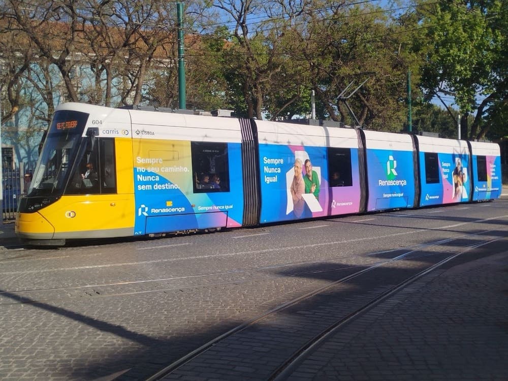 Lisbon tram moving through the city center, passing historic streets and buildings, showing a typical way how to get around Lisbon.